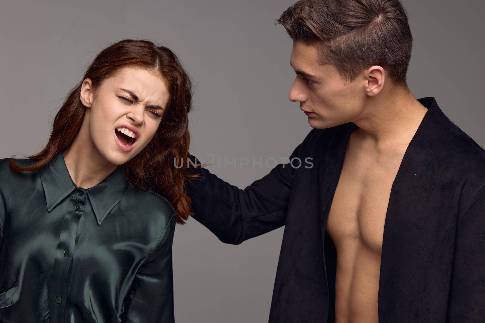 Man abuses young woman domestic violence gray background. High quality photo