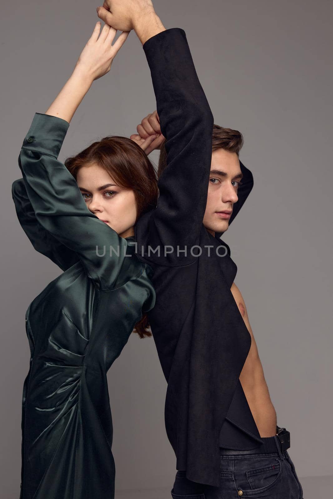 Cropped view of woman and man with hands raised up on gray background by SHOTPRIME