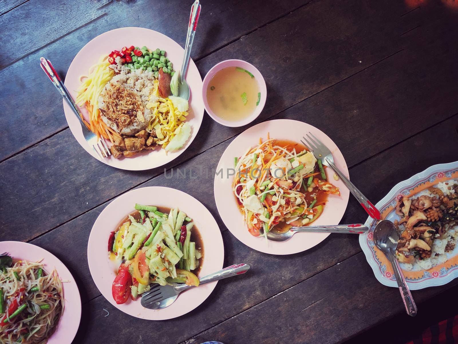 Top view Thai food on table: Eating north eastern foods (SOM TUM - Spicy Papaya Salad, Sticky rice). Local and traditional way. Thai Food Background. enjoy eating concept