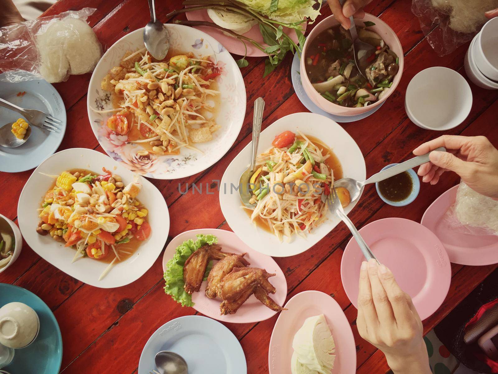 Top view Thai food on table: Eating north eastern foods (SOM TUM - Spicy Papaya Salad, Sticky rice, NUM TOK - Spicy Soup). Local and traditional way. Thai Food Background. enjoy eating concept by NarinNonthamand