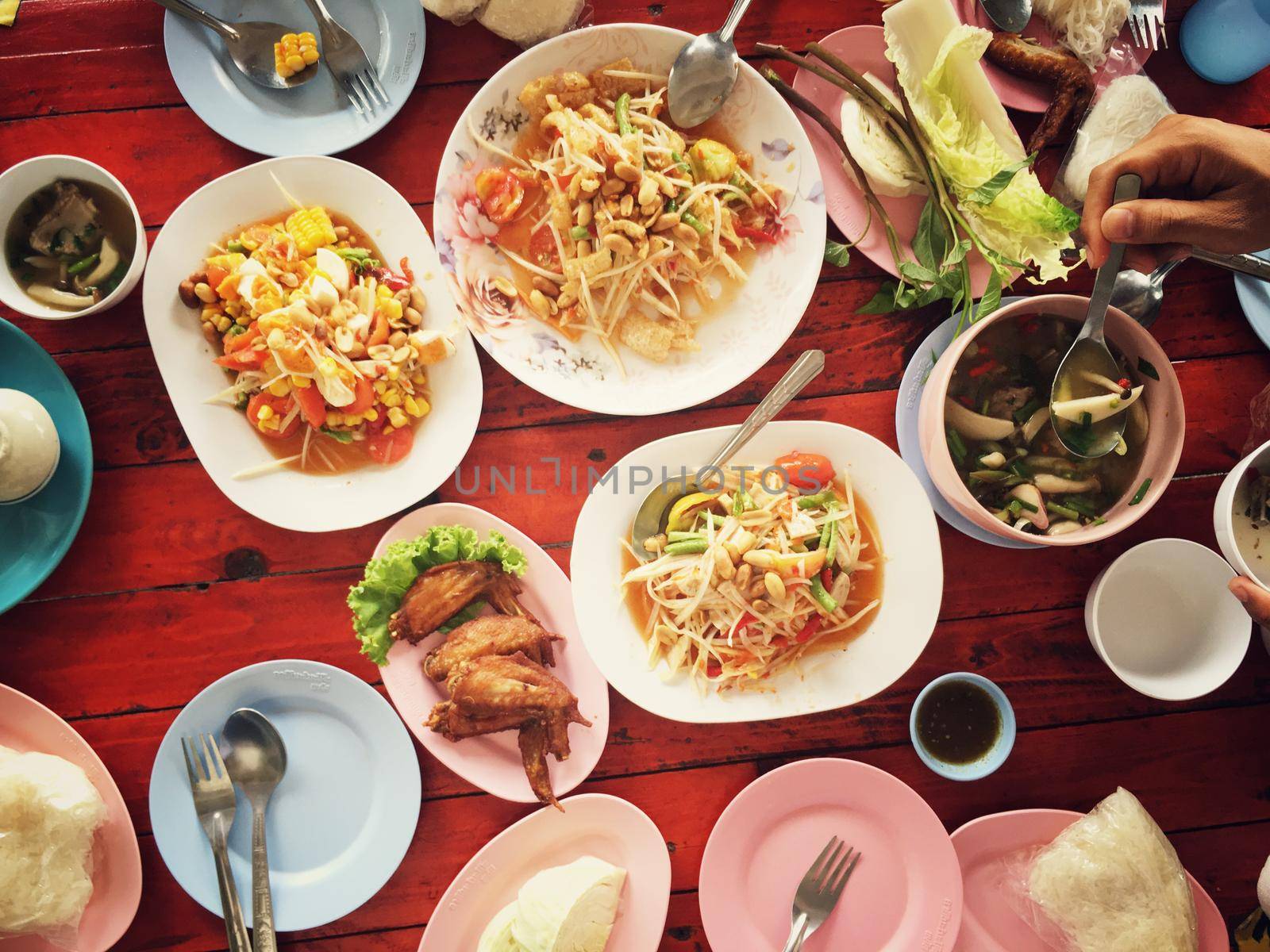 Top view Thai food on table: Eating north eastern foods (SOM TUM - Spicy Papaya Salad, Sticky rice, NUM TOK - Spicy Soup). Local and traditional way. Thai Food Background. enjoy eating concept by NarinNonthamand