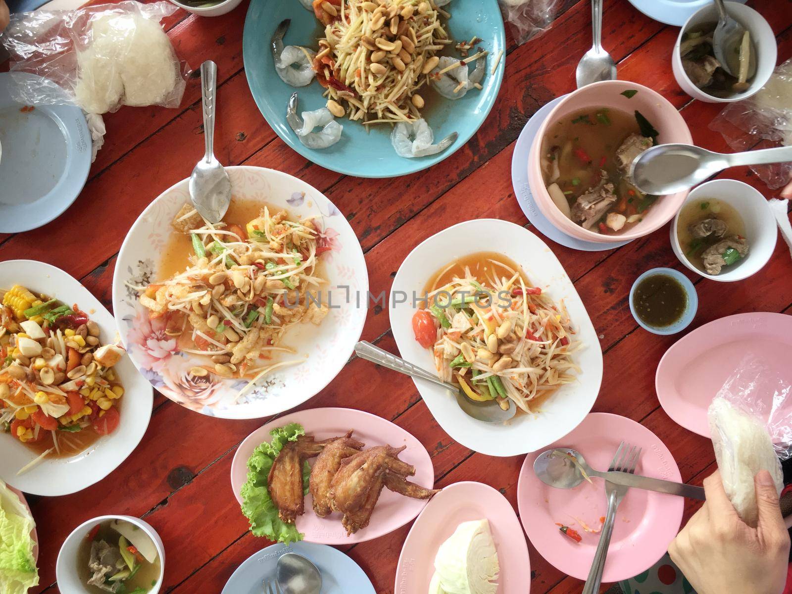 Top view Thai food on table: Eating north eastern foods (SOM TUM - Spicy Papaya Salad, Sticky rice, NUM TOK - Spicy Soup). Local and traditional way. Thai Food Background. enjoy eating concept