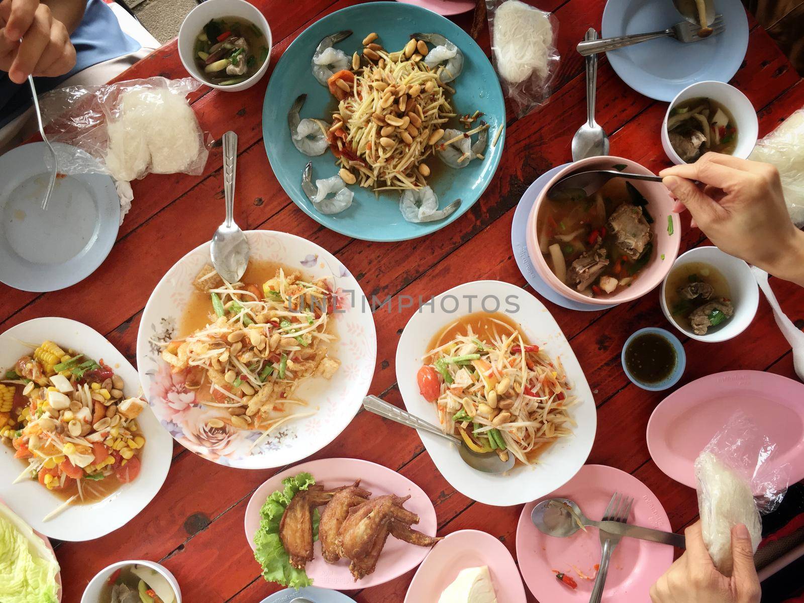 Top view Thai food on table: Eating north eastern foods (SOM TUM - Spicy Papaya Salad, Sticky rice, NUM TOK - Spicy Soup). Local and traditional way. Thai Food Background. enjoy eating concept