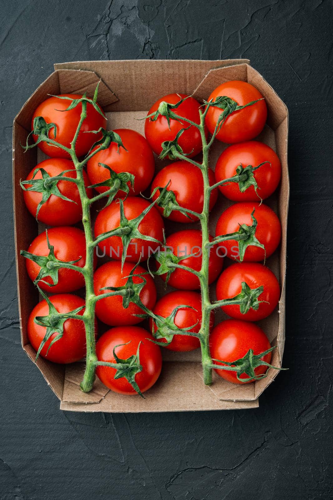 Ripe cherry tomatoes, on black background, top view