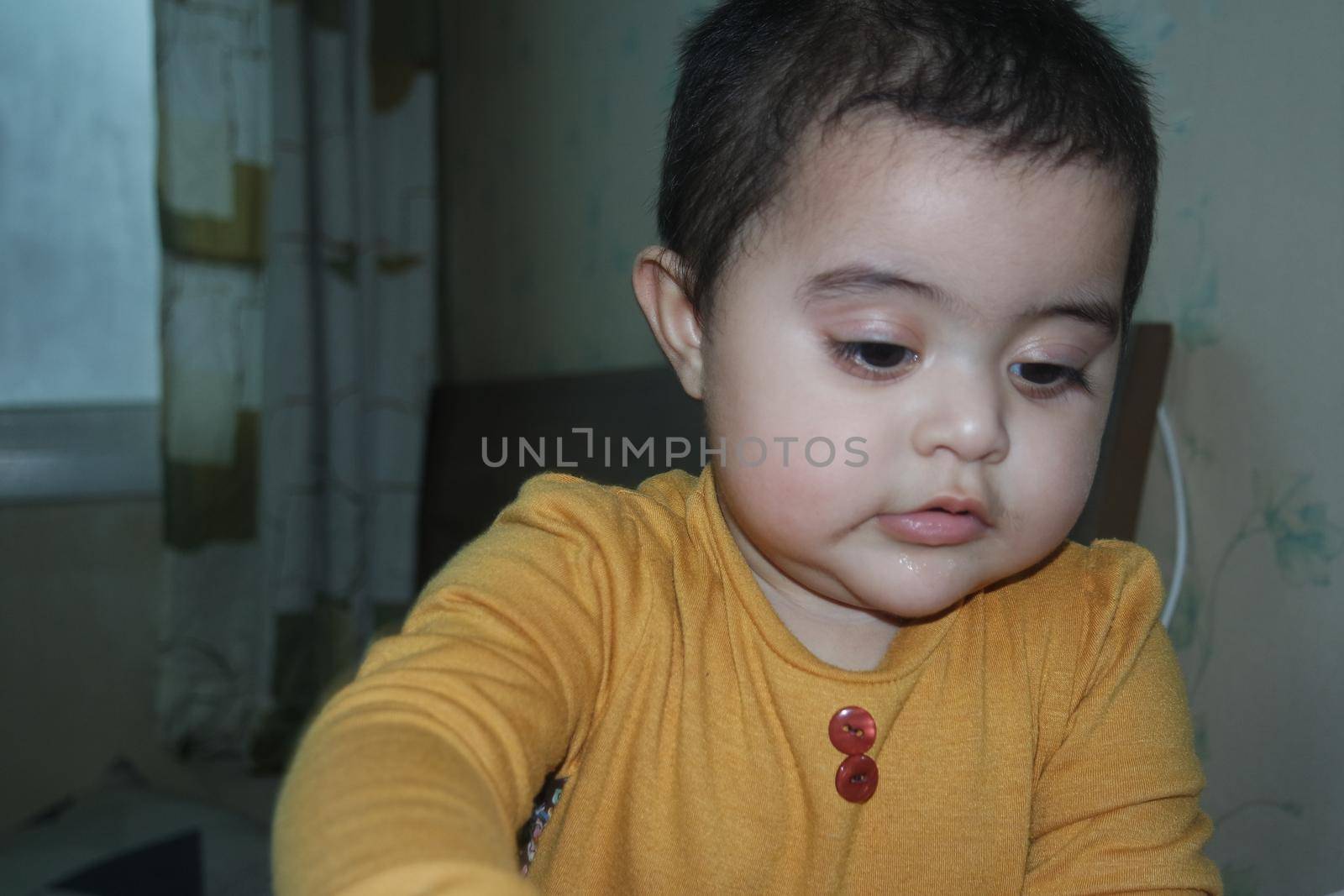 Toddler baby playing with toys. Baby girl with lovely face, big eyes and cute face gesture.