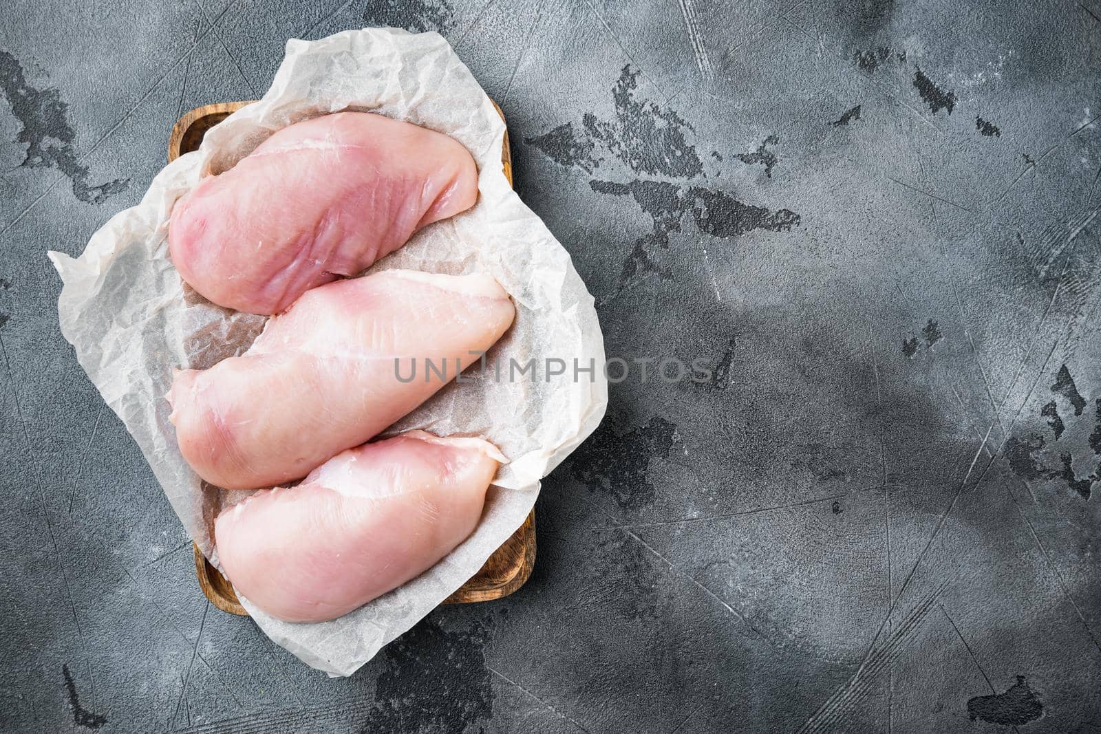 Chicken uncooked meat on grey background, flat lay with copy space