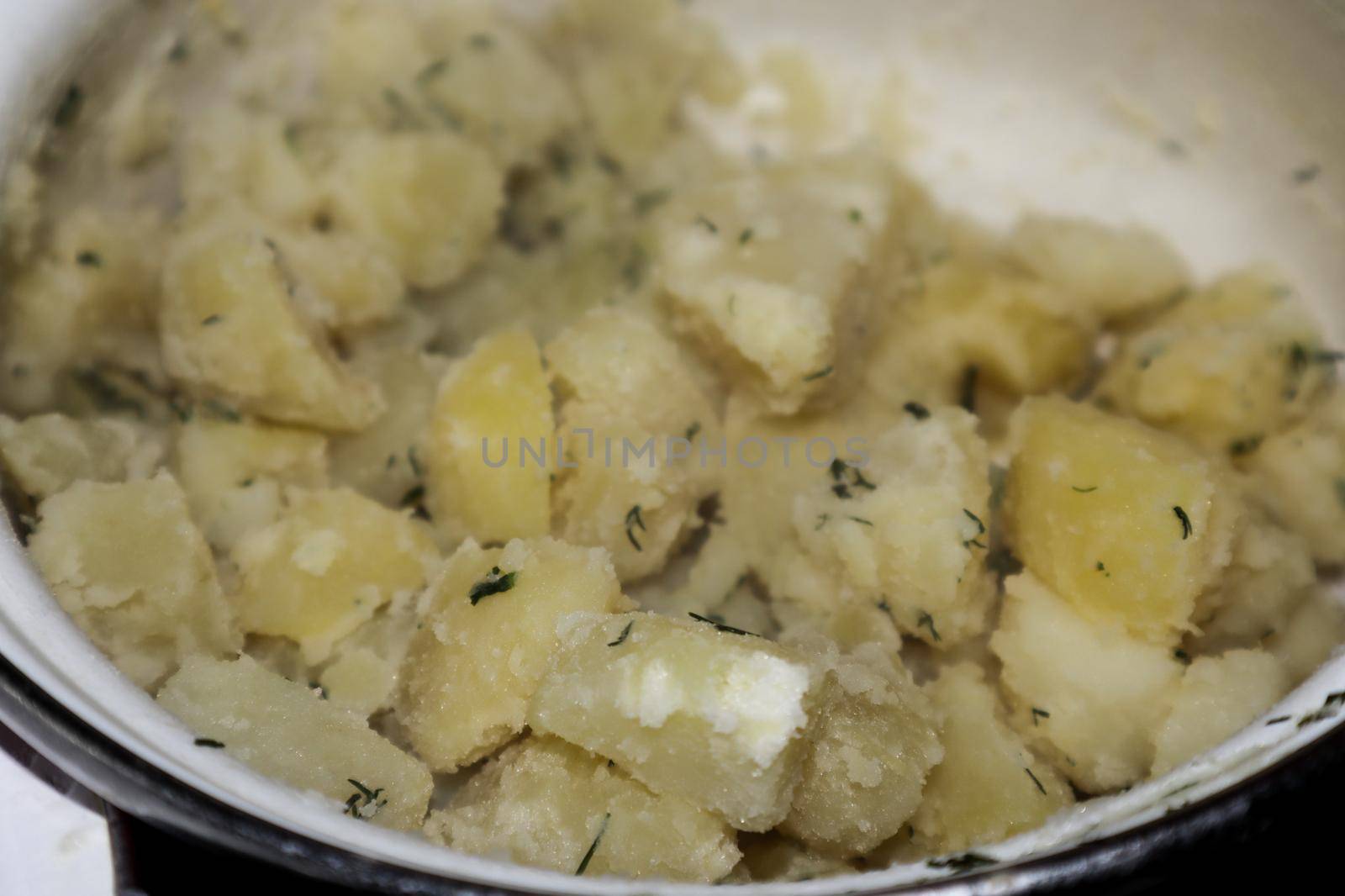 Potatoes with dill in an enamel pan