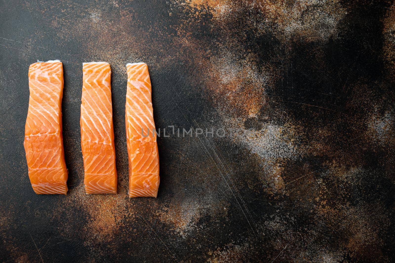 Raw salmon fillet, on old rustic background, flat lay with space for text