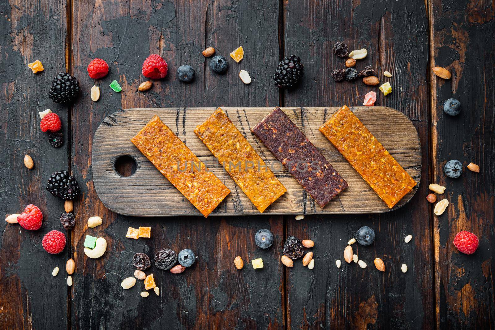 Healthy fitness energy bars with dried fruits and nuts, top view, on wooden table