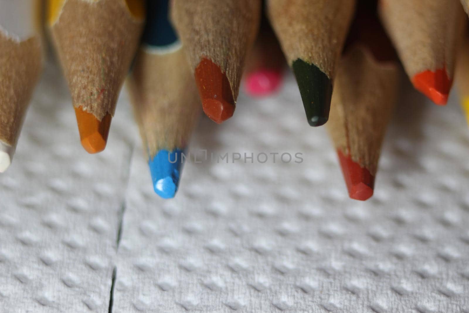 Close-up view of bright colored multicolor pencils on black background