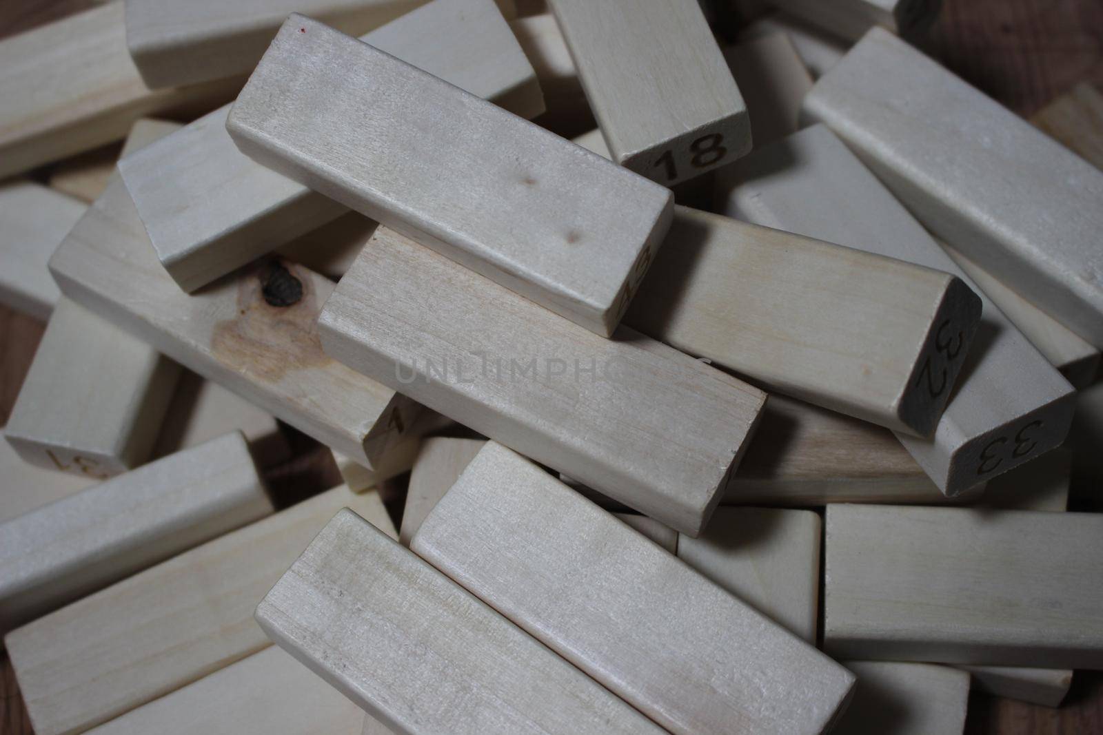 Pile of wooden blocks with engraved letters dispersed on floor. Children toy for building creative works.