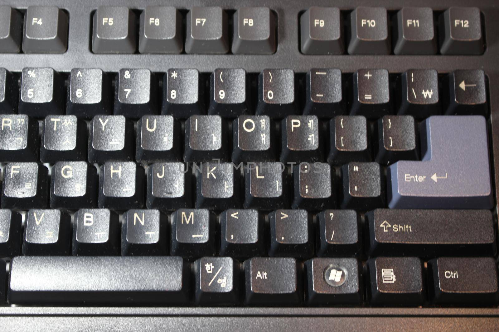 Closeup of laptop computer keyboard black keys with white letters and numbers. Black keys with white characters.