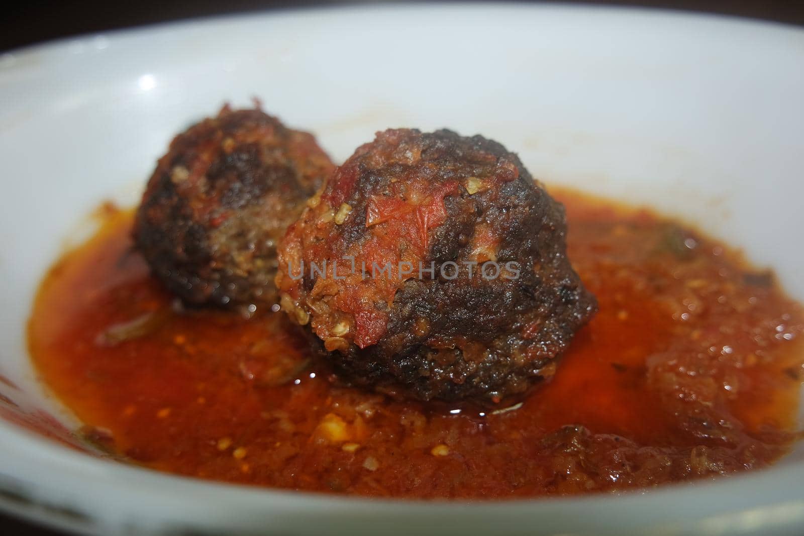 Closeup view with selective focus of meatball dish.Top view of meat balls or meat kofta curry in masala gravy in a ceramic plate.