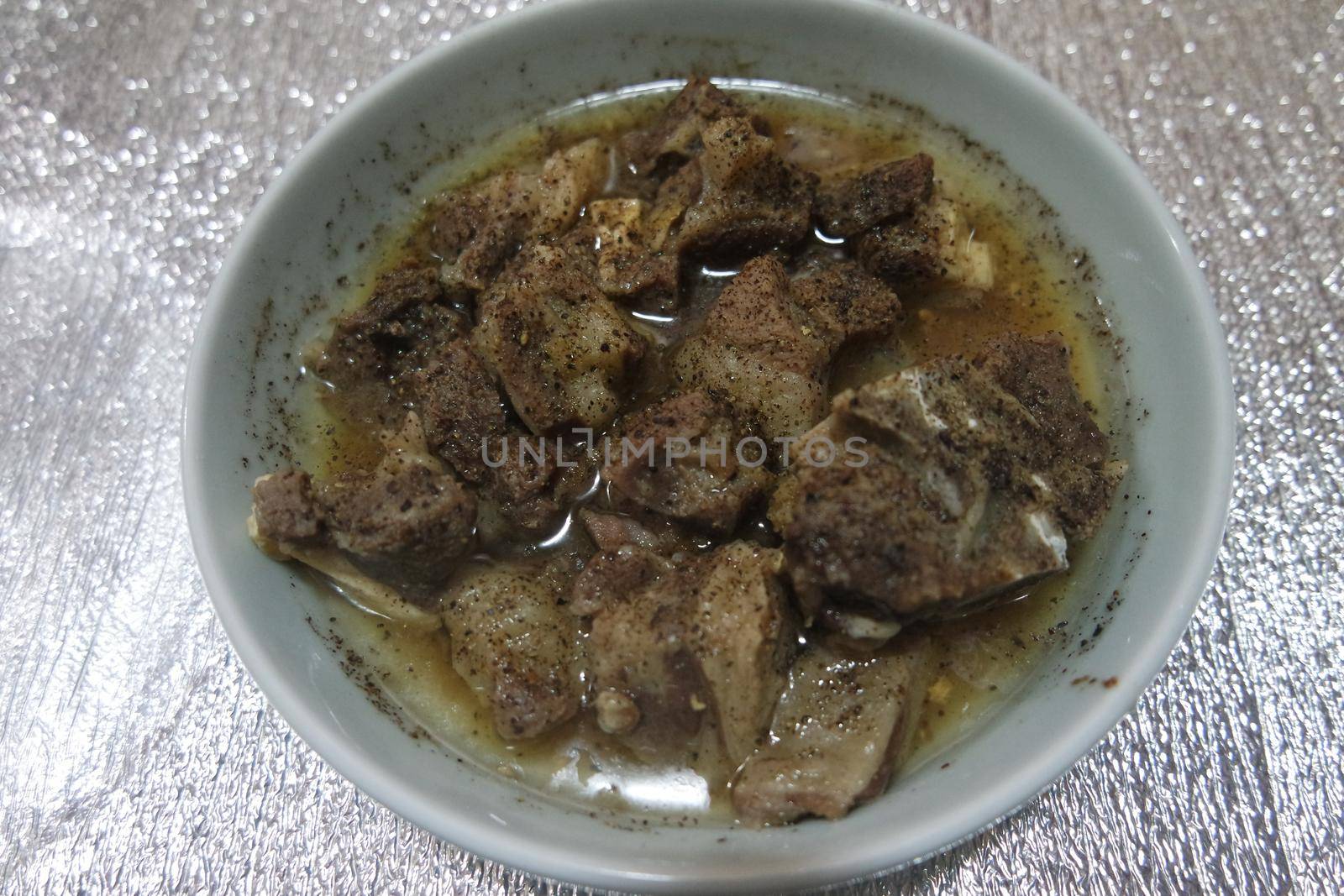 Top view of siri paaye or paya dish garnished with diced ginger, long coriander and black pepper. This dish is popular in Pakistan and Bangladesh