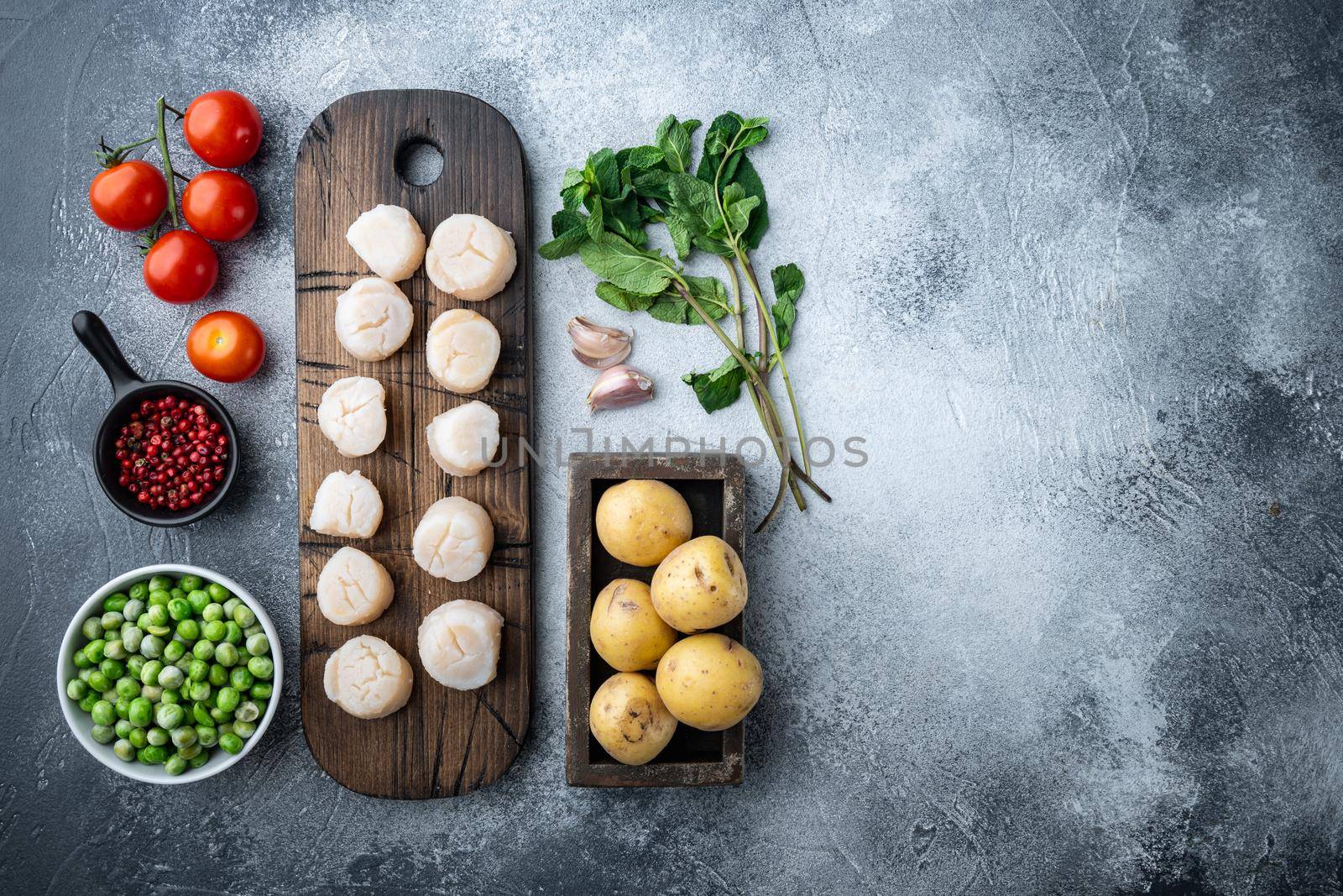 Sea delicacies, scallops with potato, green pea and mint, top view, on grey background with copy space