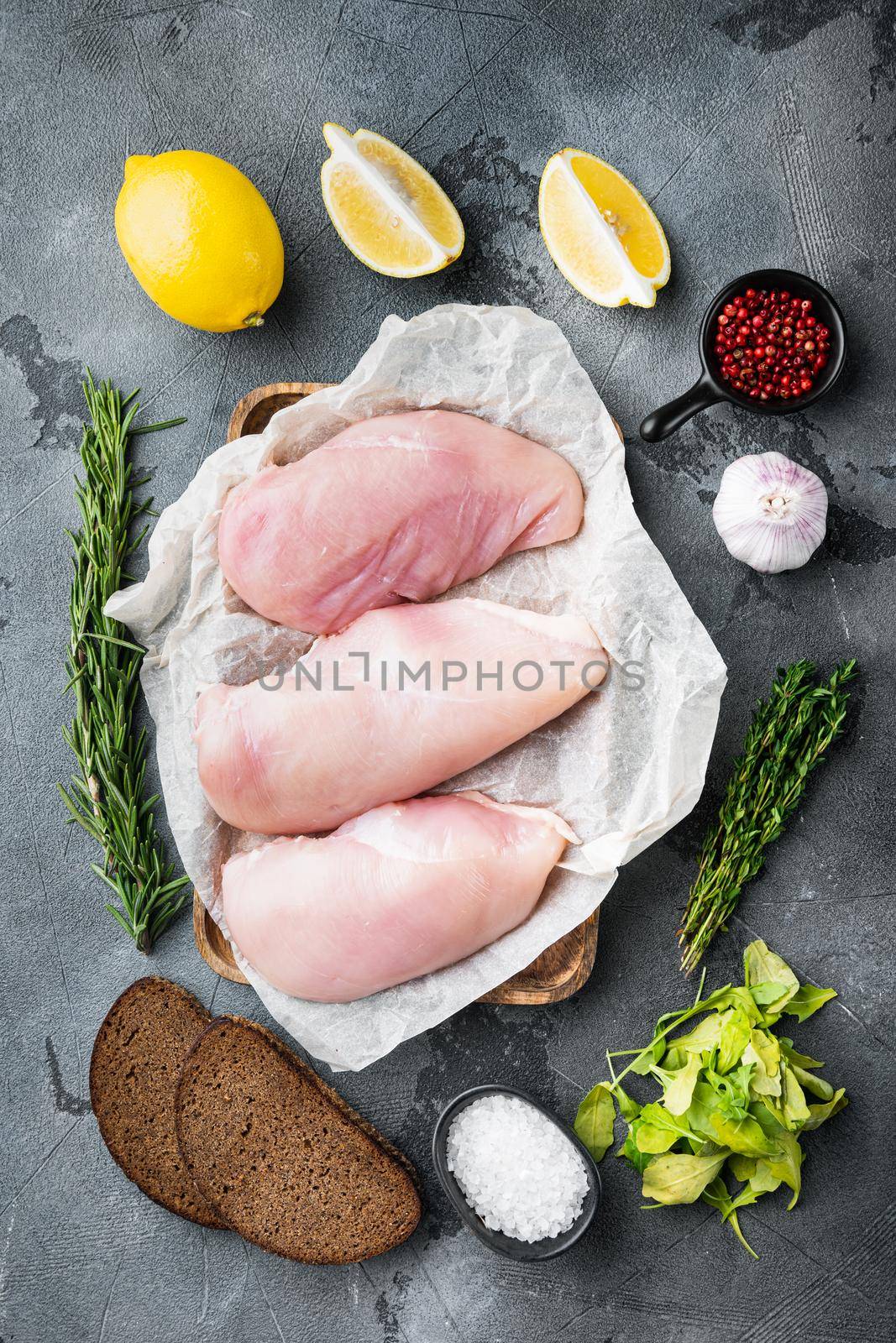 Crumbed uncooked chicken breasts ingredient on grey background, top view