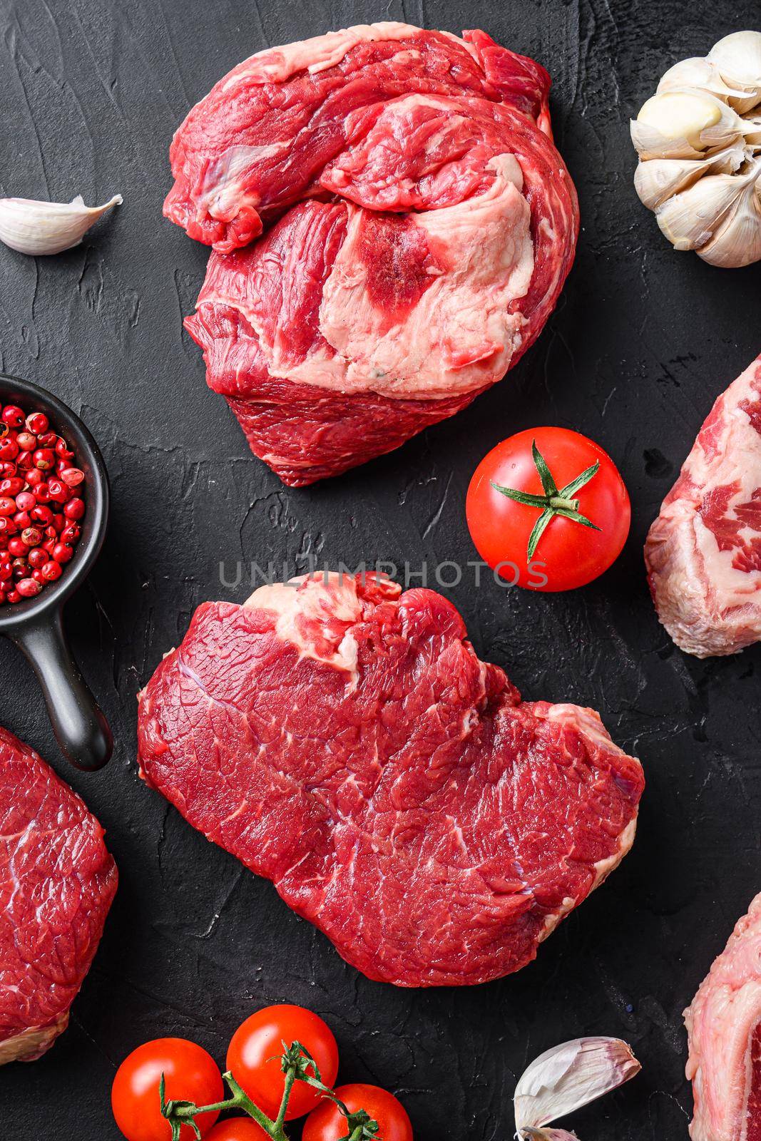 Rump and chuck roll, beef steak cuts, with herbs, seasoning on black table, top view