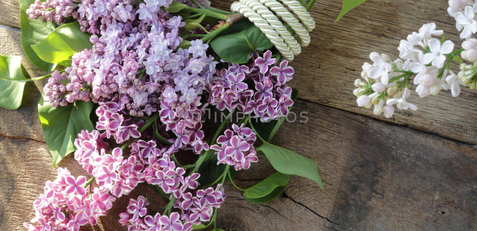 bunch of spring flowers lilac on wooden background. Top view copy space