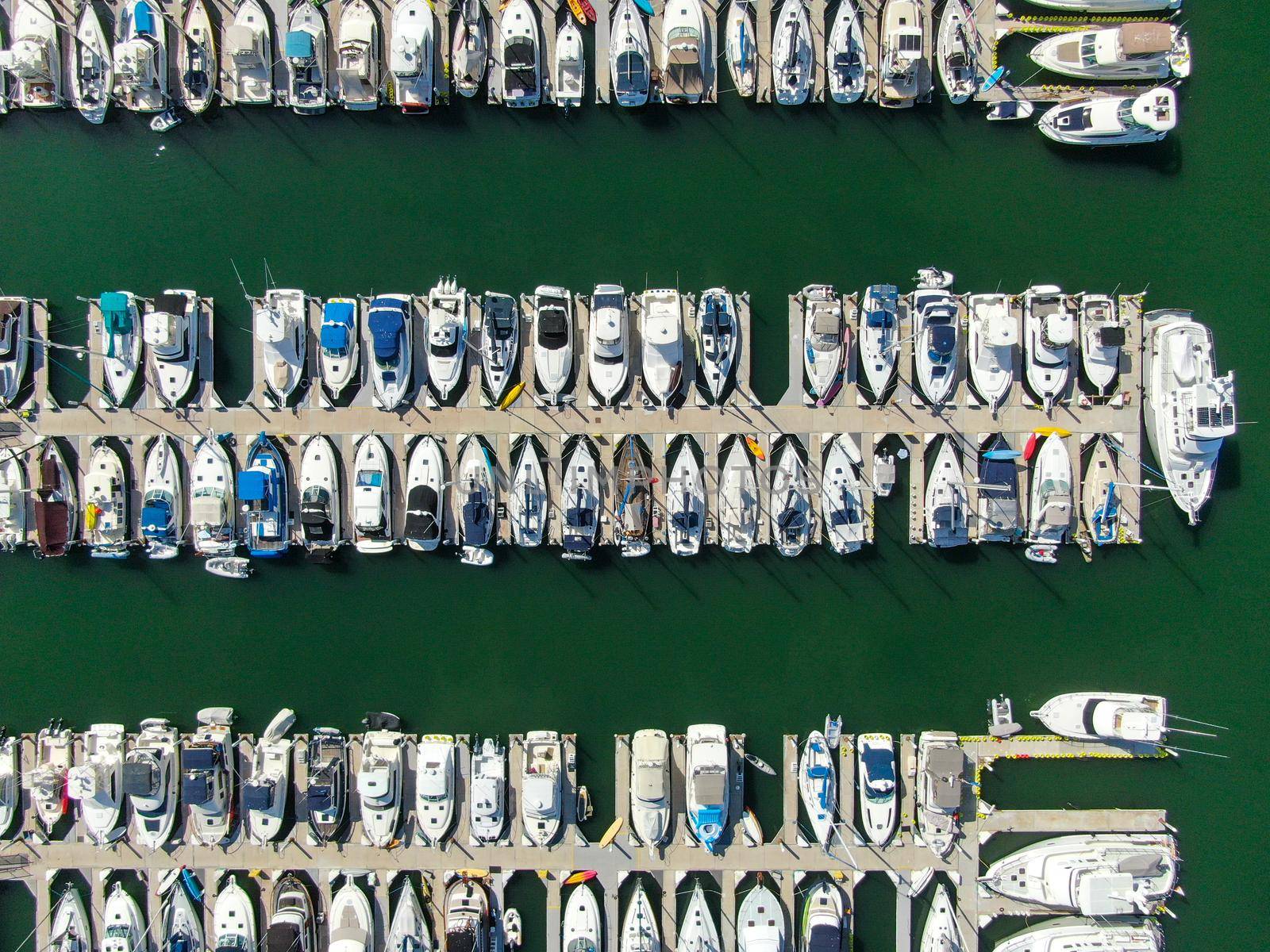 Aerial top view of boats and yachts in marina. Marina lot with yachts, sailboat and speedboat moored at the quay.