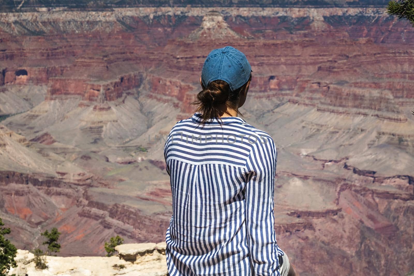 Pretty female enjoys vantage point view on Grand Canyon Arizona, USA.