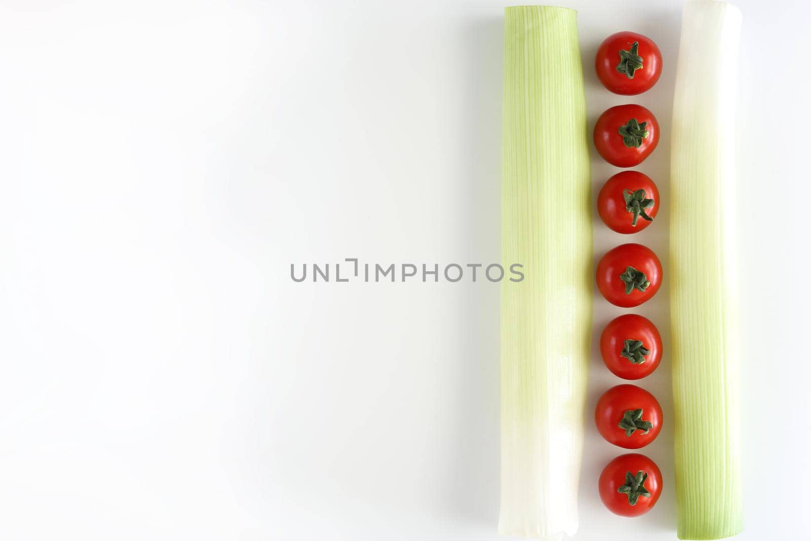 Tomatos with green leek on white background.