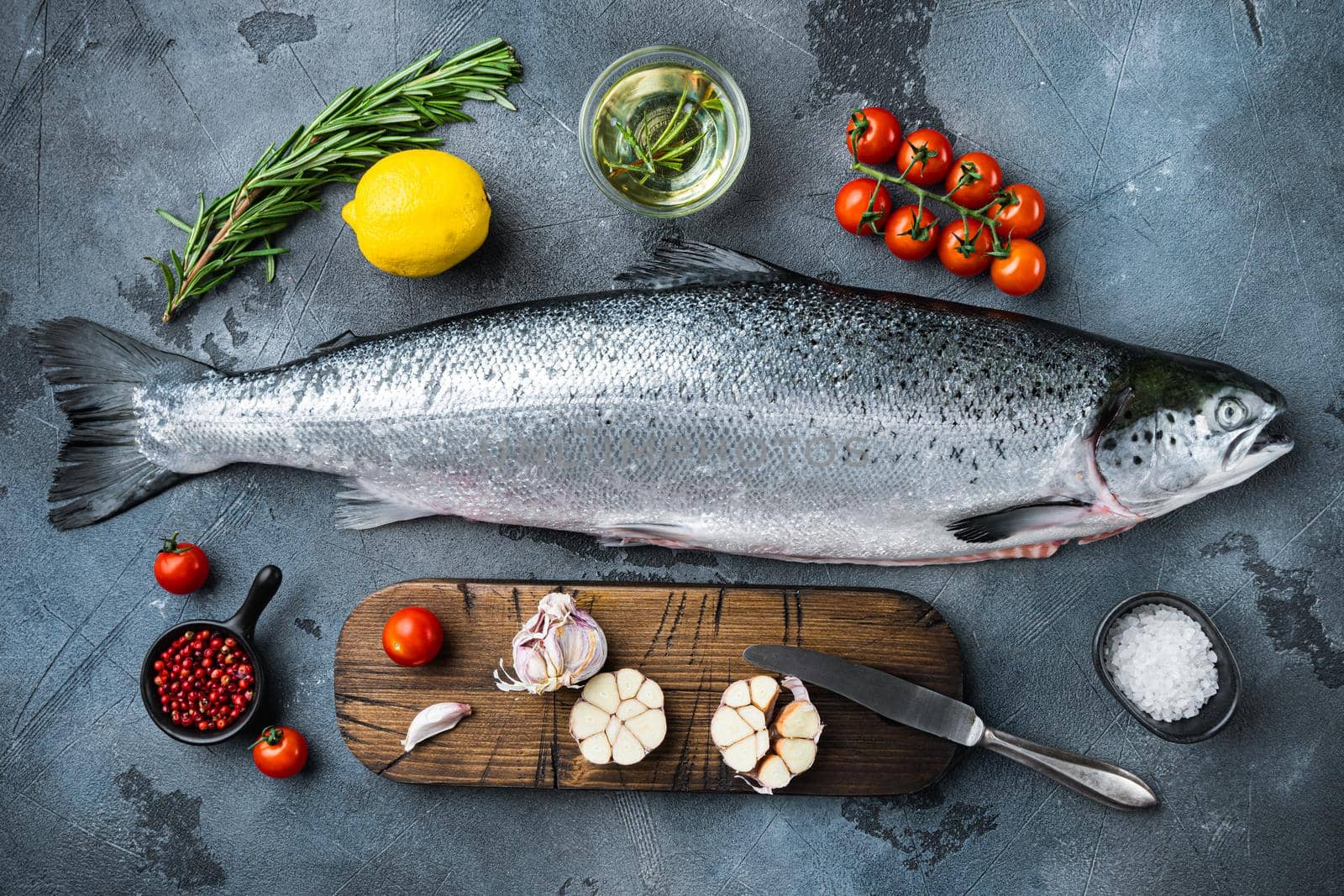 Fresh raw salmon red fish fillet on grey background, top view.