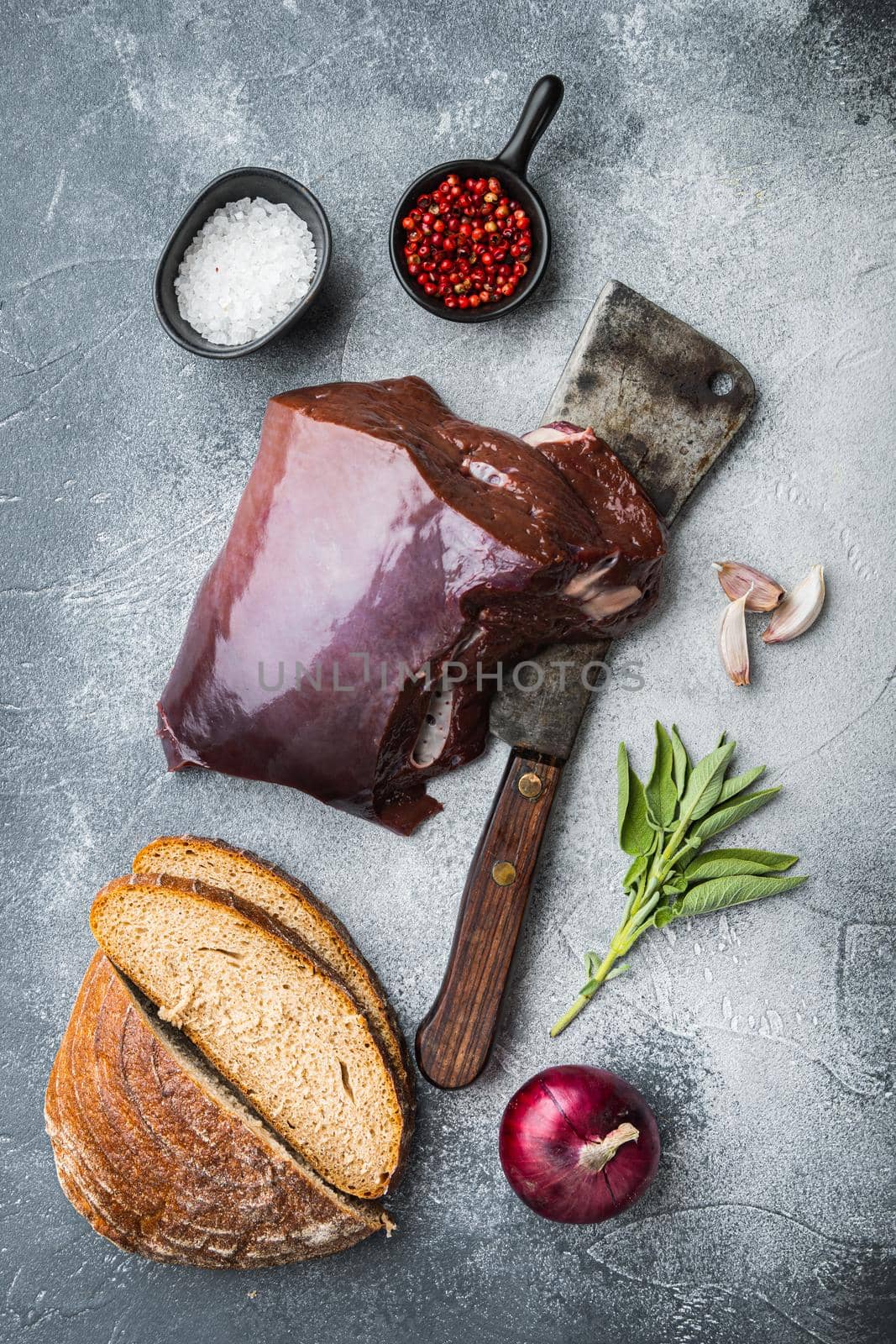 Raw liver on grey background, flat lay.