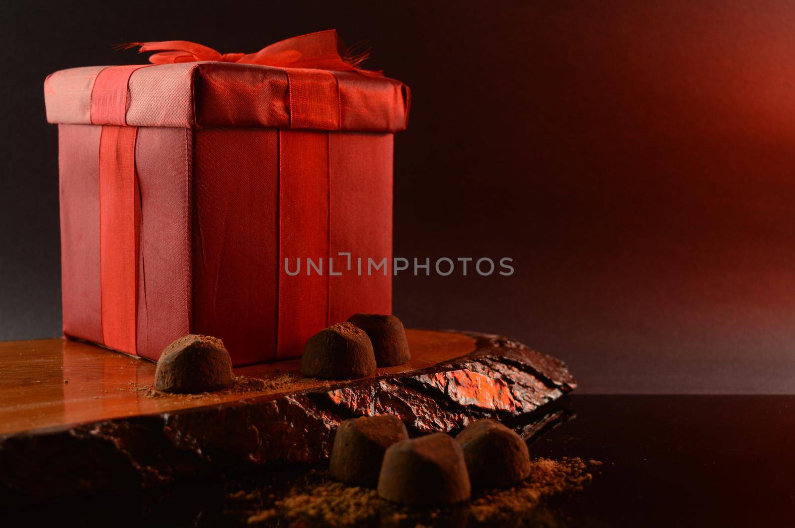 A red gift box and fine chocolate truffles to set a romantic scene.