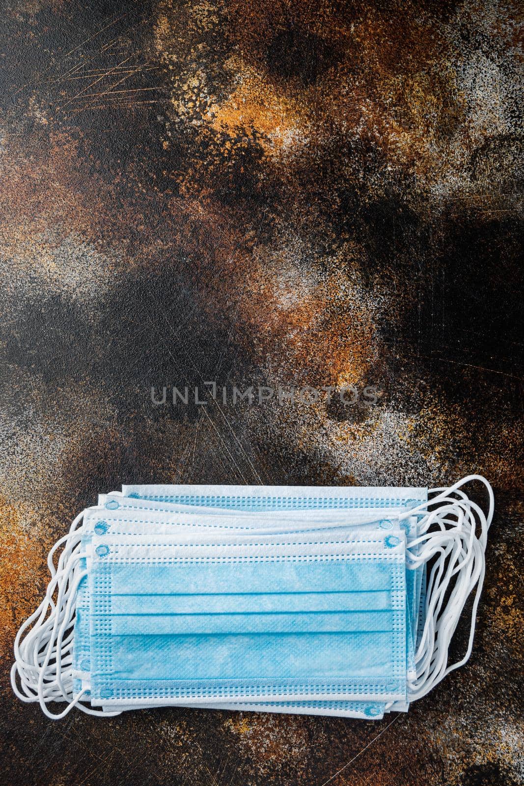 Medical protective disposable mask, surgical mask, coronavirus quarantine, hygiene concept, top view with copy space, on old dark table