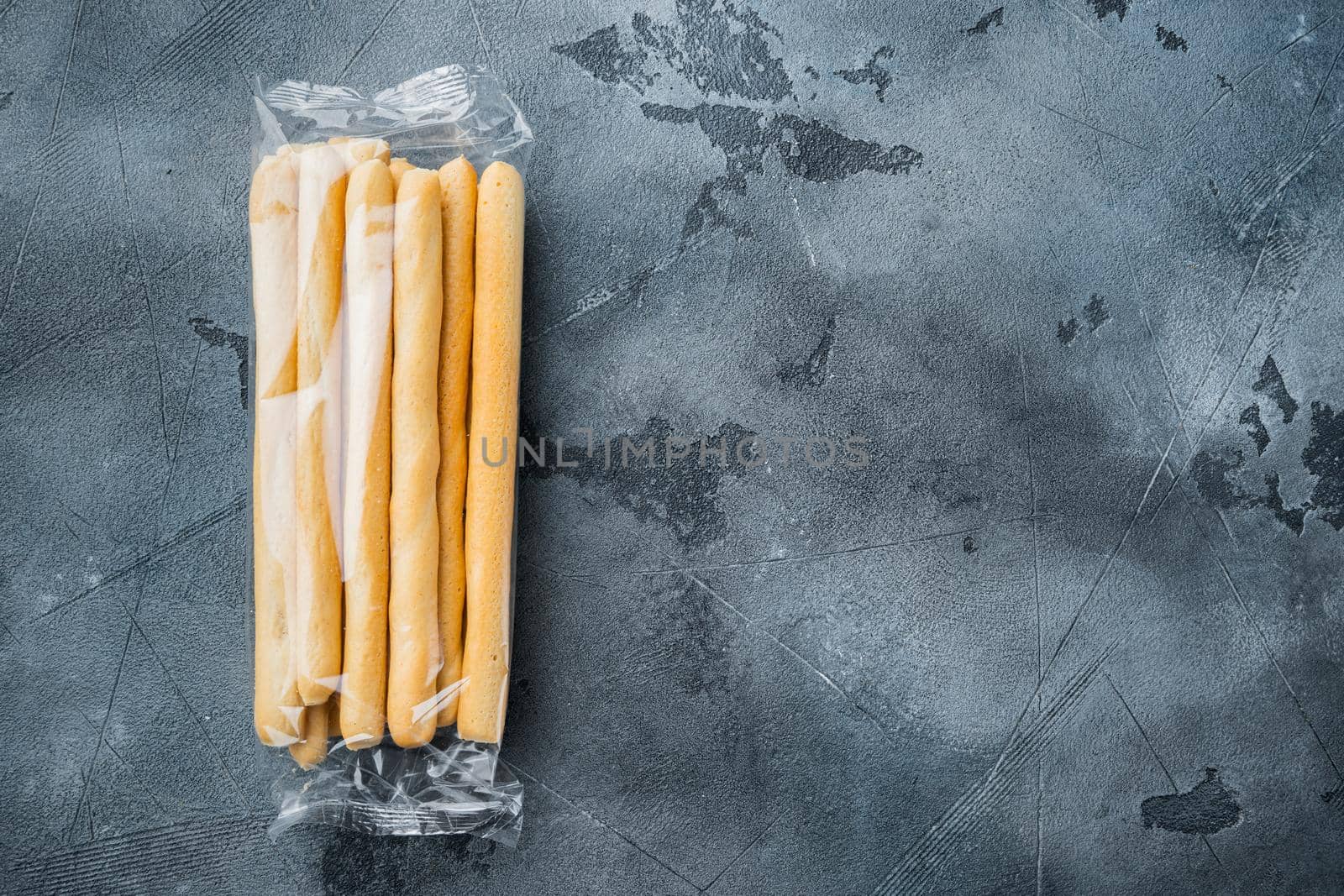 Breadsticks, with olive oil, on gray background, flat lay with copy space for text