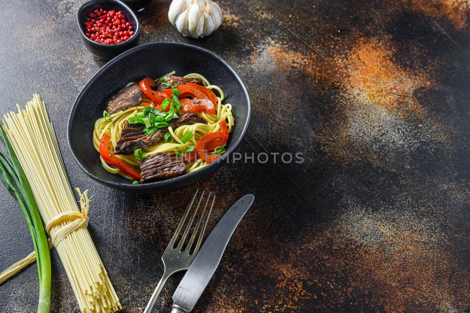 Wok with noodles and stir fry beef side view space for text