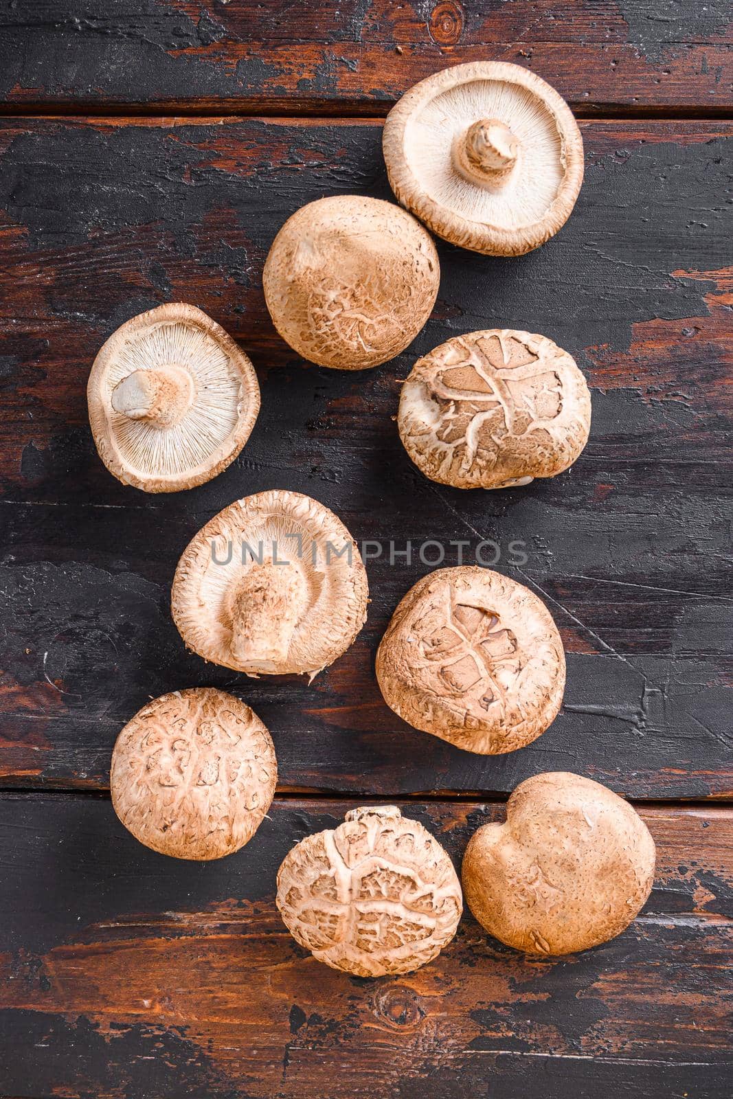 Shiitake mushrooms set on old wooden table, top view