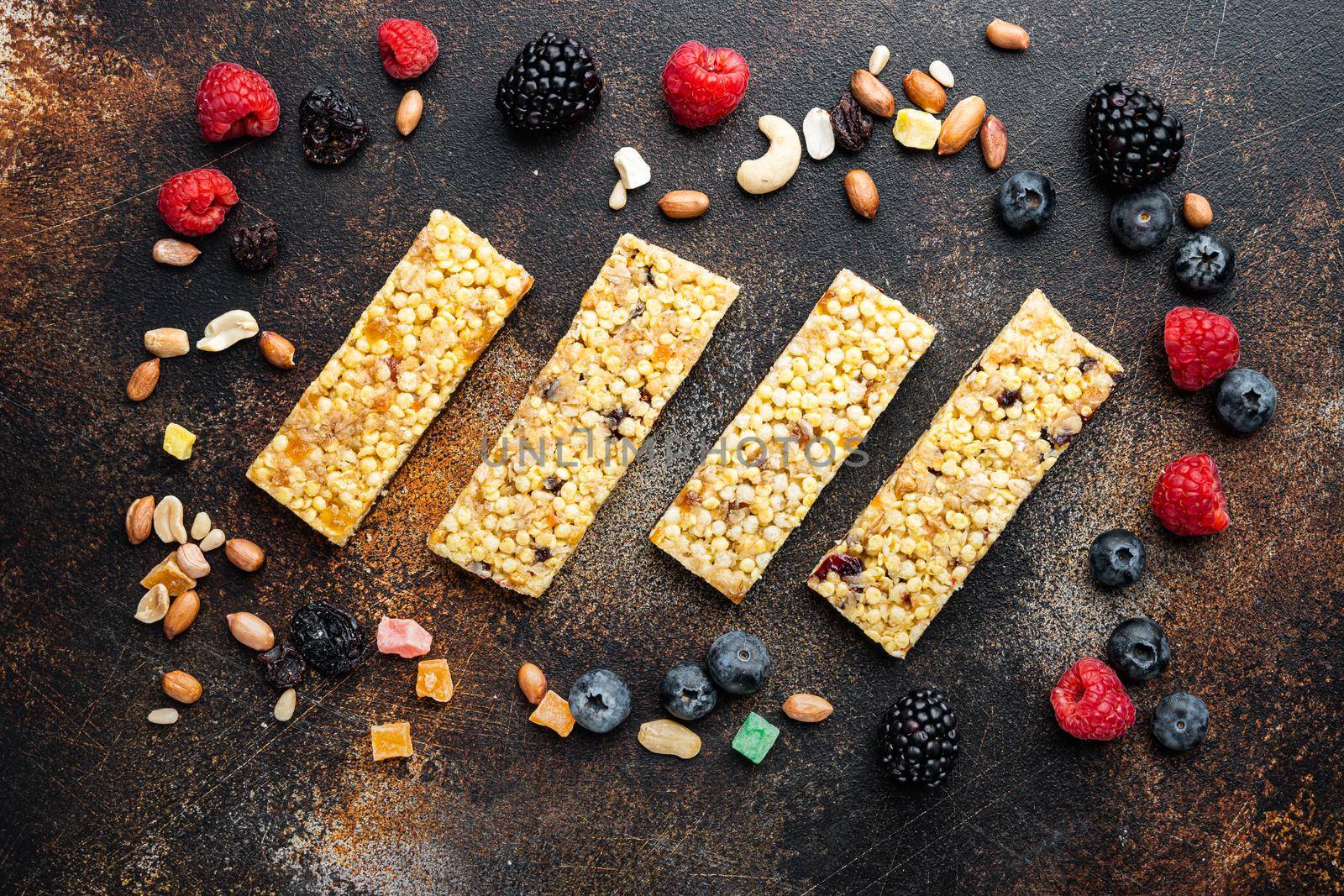 Granola energy bars with nuts, seeds, berry, top view, on old dark table