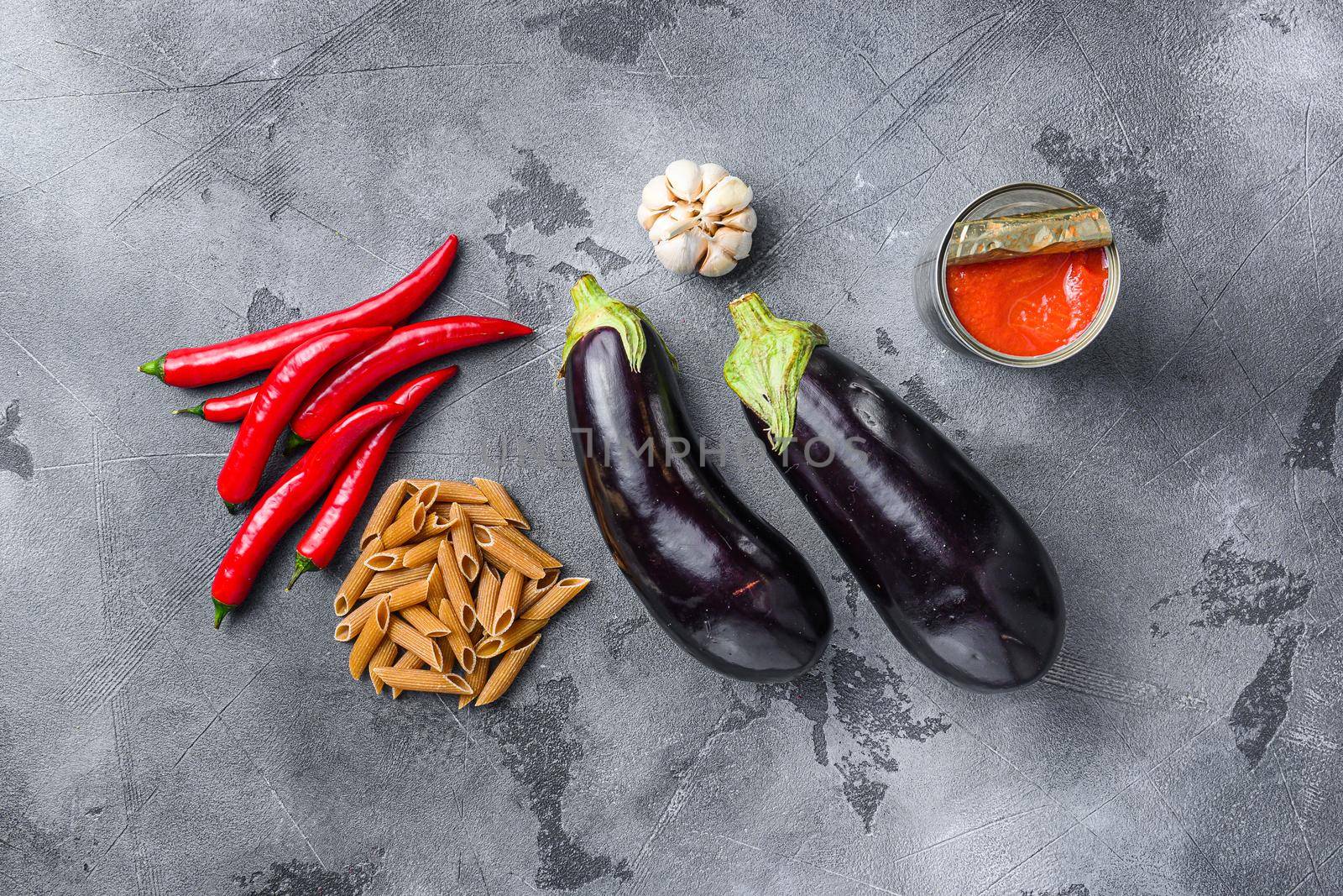 Aubergine penne ingredients eggplant pasta, pepper tomatoe sauce, on grey background top view