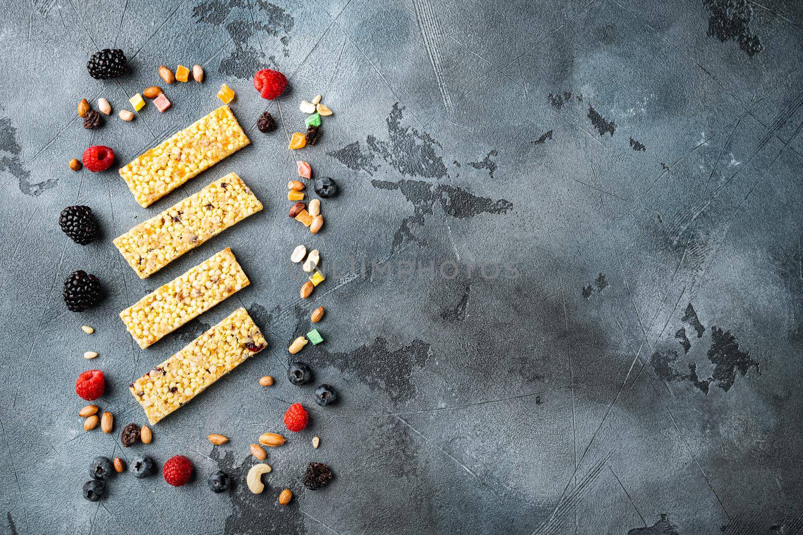 Superfood breakfast bars with oats nuts and fresh berries, top view with copy space, on grey background
