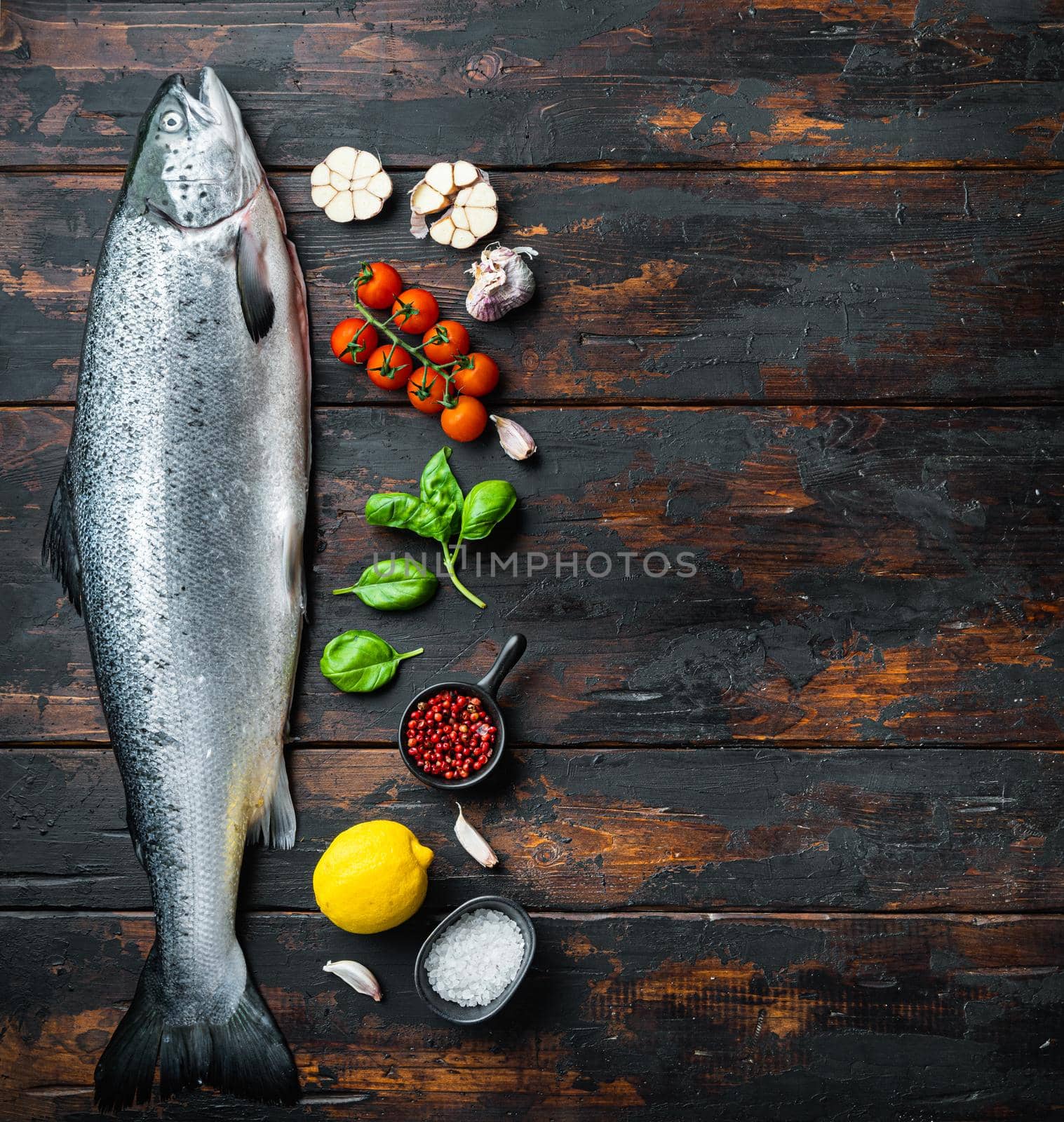 Fresh whole salmon on wooden background, top view with copy space.