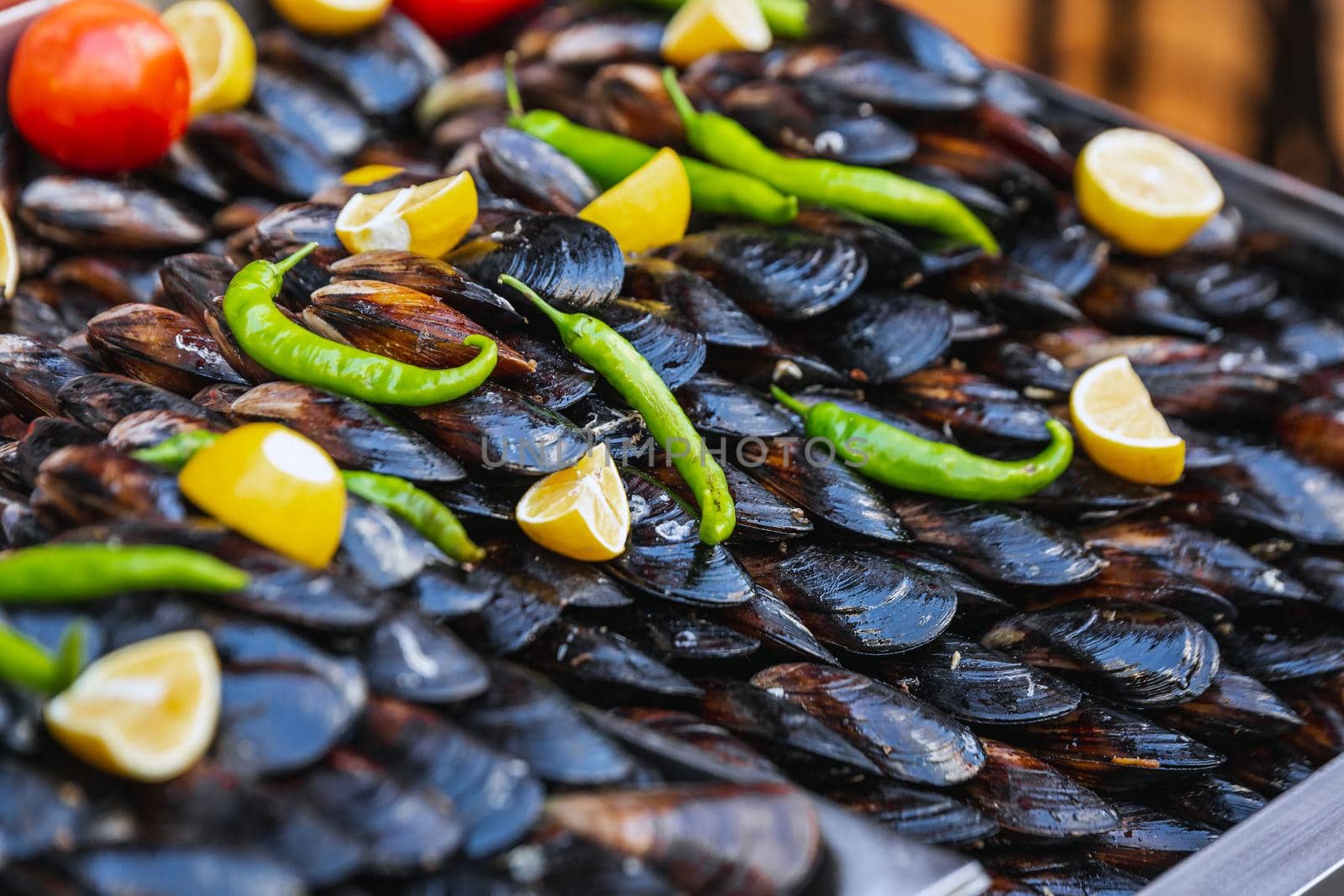 Turkish style appetizer street food stuffed mussels called midye dolma on bench for sale with lemon which is served with a squirt of lemon juice in Istanbul, Turkey.