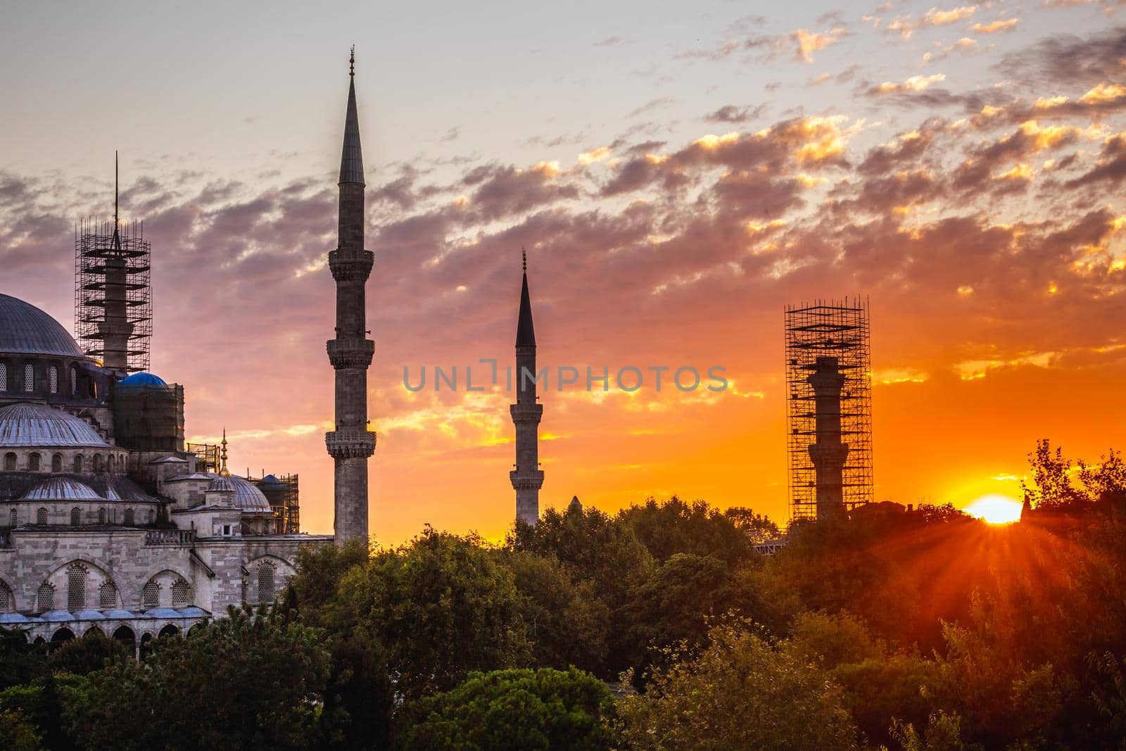 Blue mosque is under a renovation in Istanbul, Turkey. Shot during amazing sunset with clouds and Bosporus at the background.