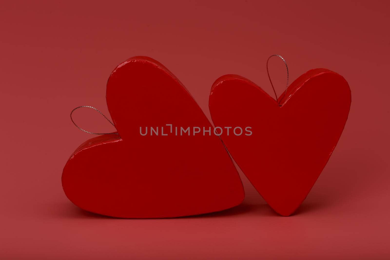 Two heart shaped red gift boxes on dark pink background. Concept of St. Valentine's day and presents by Senorina_Irina