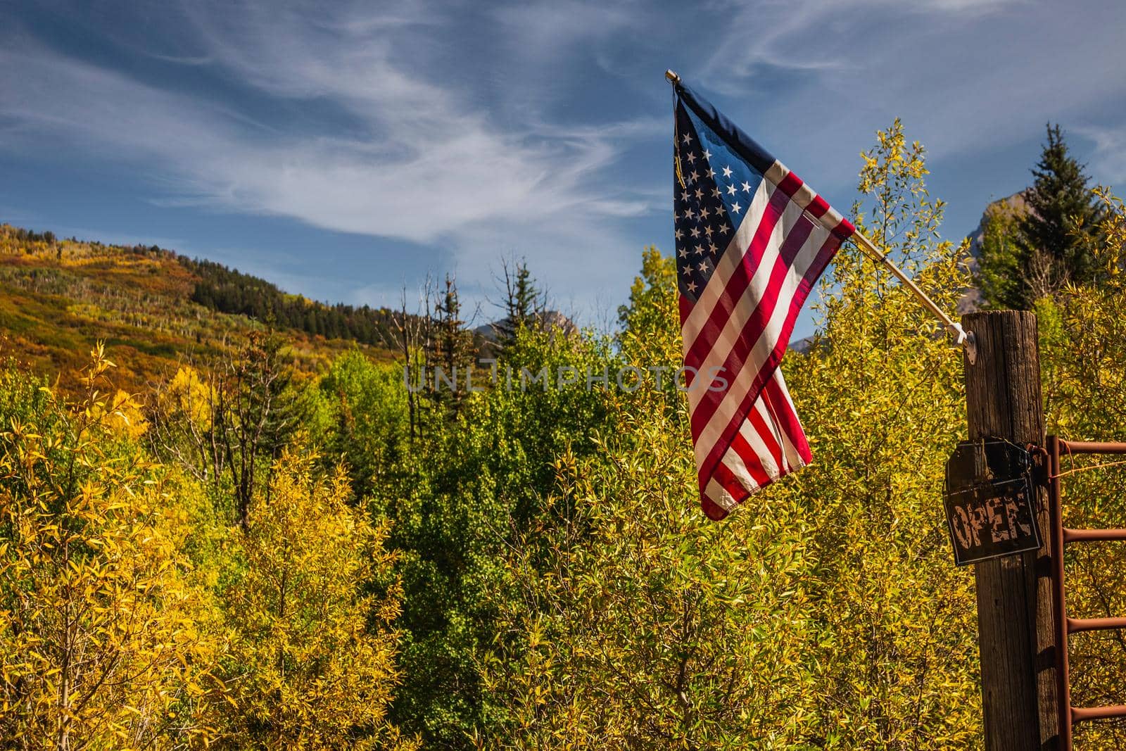 American flag with beautiful yellow autumn aspen tree leaves at the background. Taken in Black Hawk city turned into gambling destination of Colorado Rocky Mountains, USA.