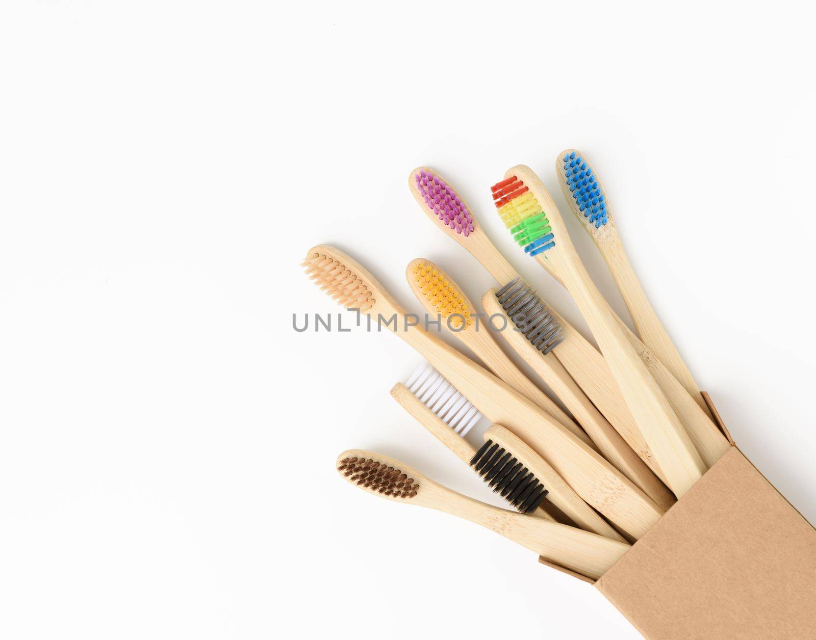 multicolored wooden toothbrushes on a white background, plastic rejection concept, zero waste, close up
