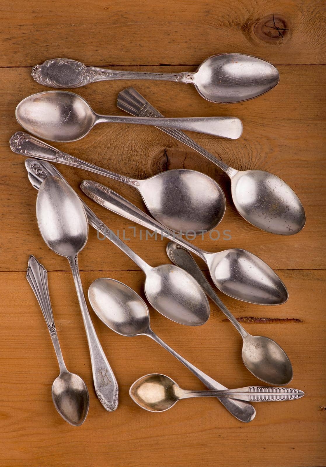 Vintage cutlery. different spoons on wooden background. Antique silverware. Retro. by aprilphoto