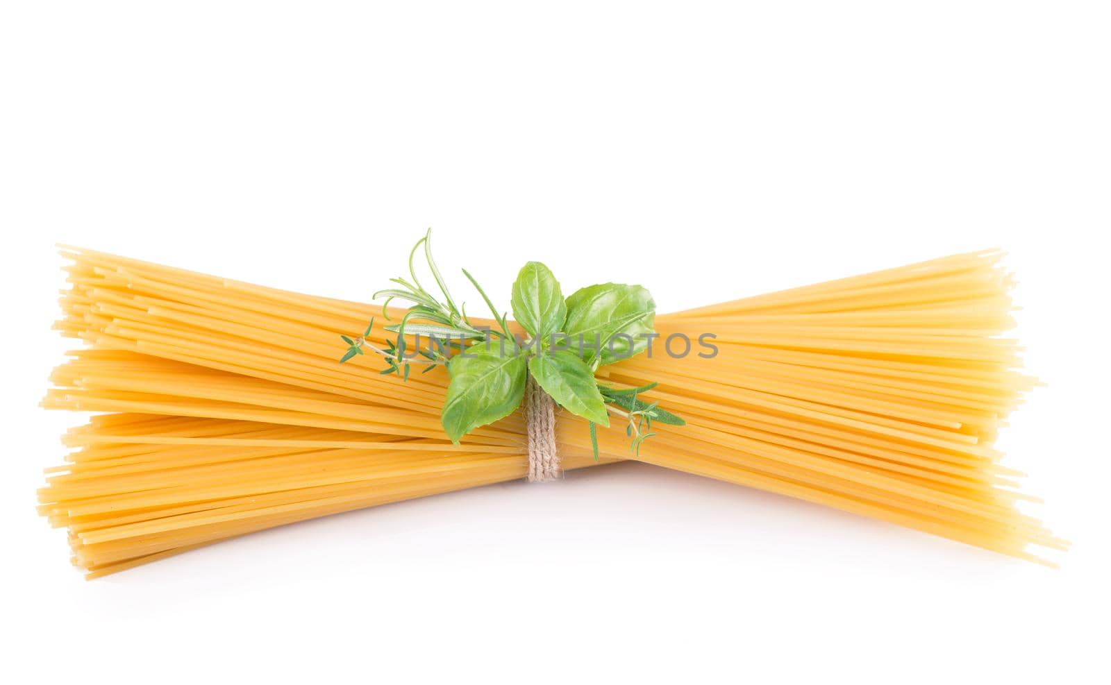 Raw tagliatelle pasta and basil isolated on white background