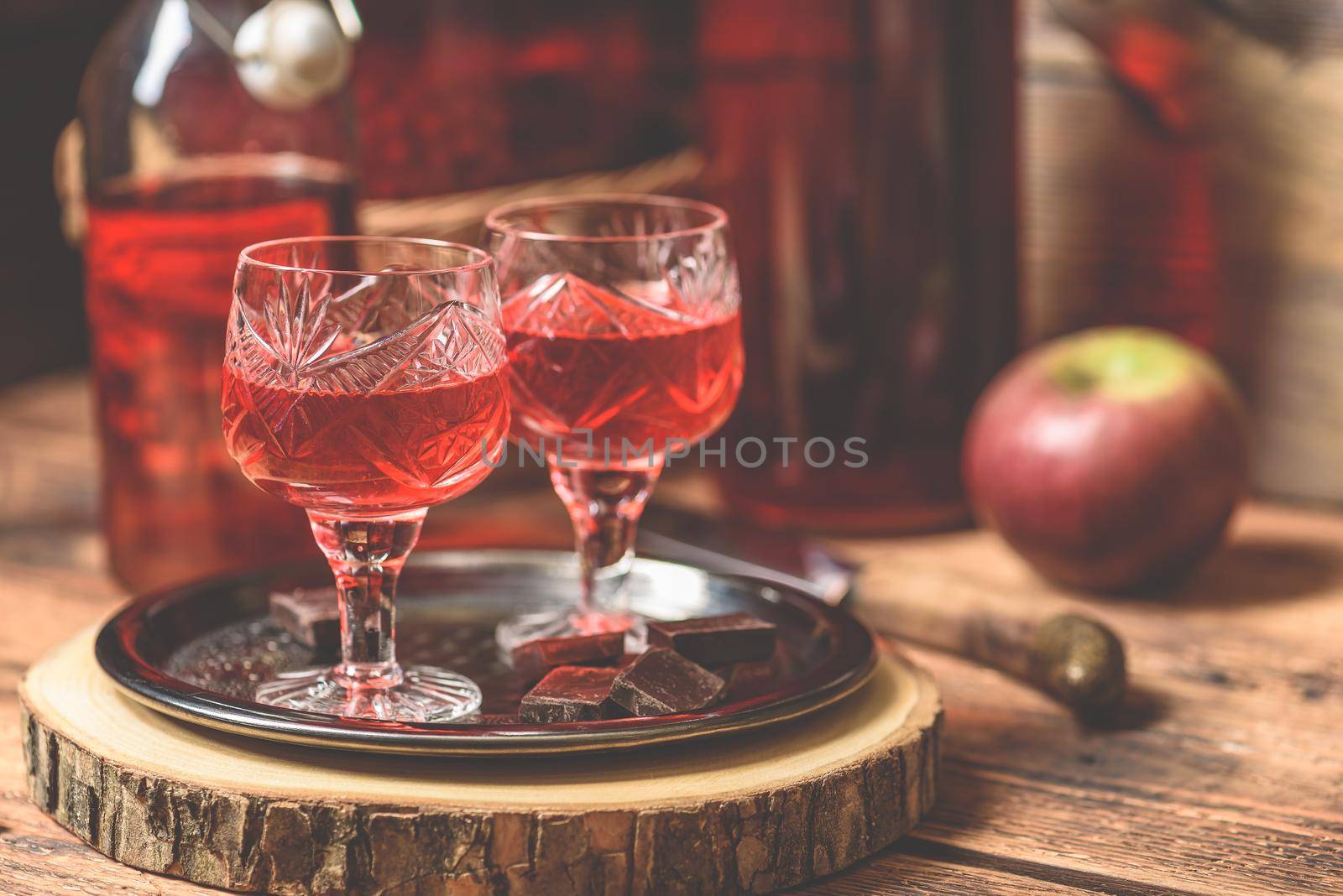 Homemade berry alcoholic beverage and chocolate bars on metal tray