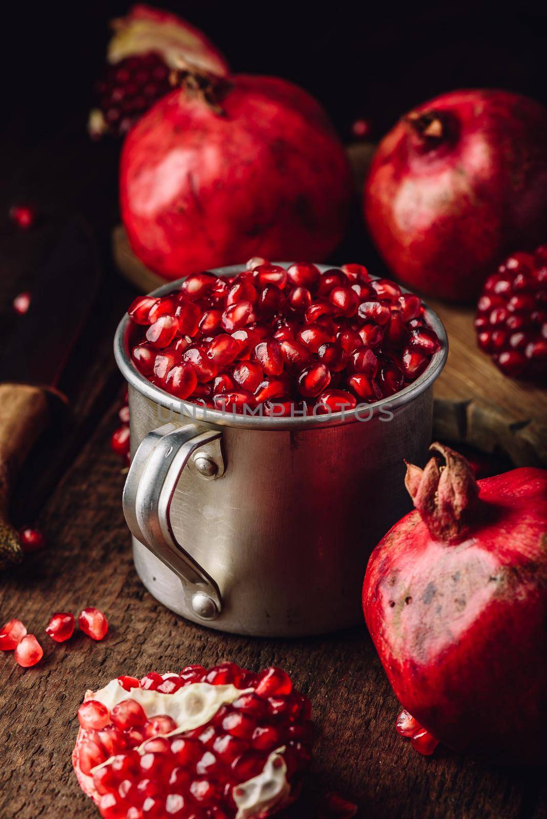 Metal mug full of pomegranate seeds by Seva_blsv