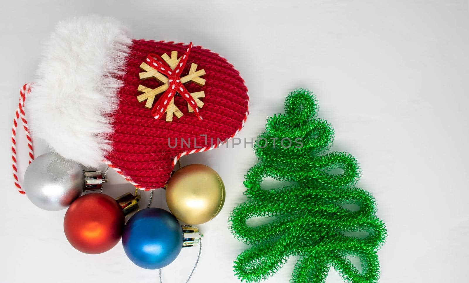 Red mitten lying in the snow in the winter. Festive decoration. Christmas and new year traditions. Christmas composition. Space for your text.