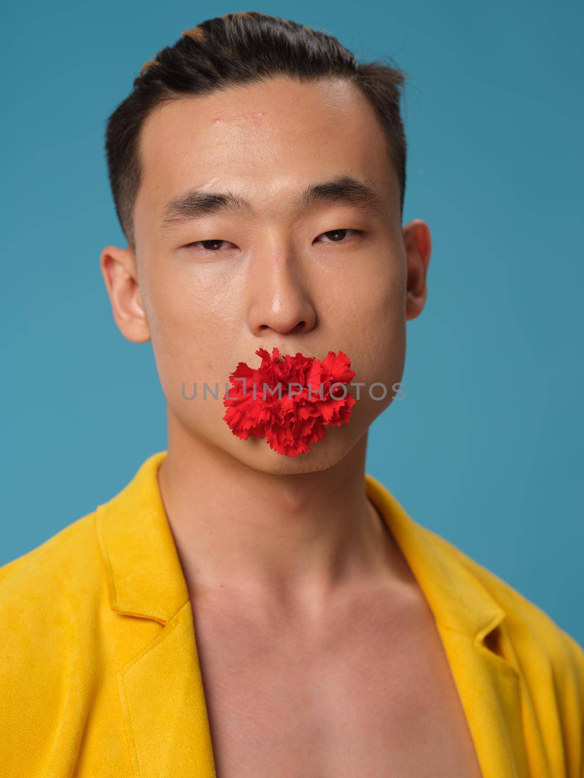sexy guy with flower on blue background portrait closeup model. High quality photo