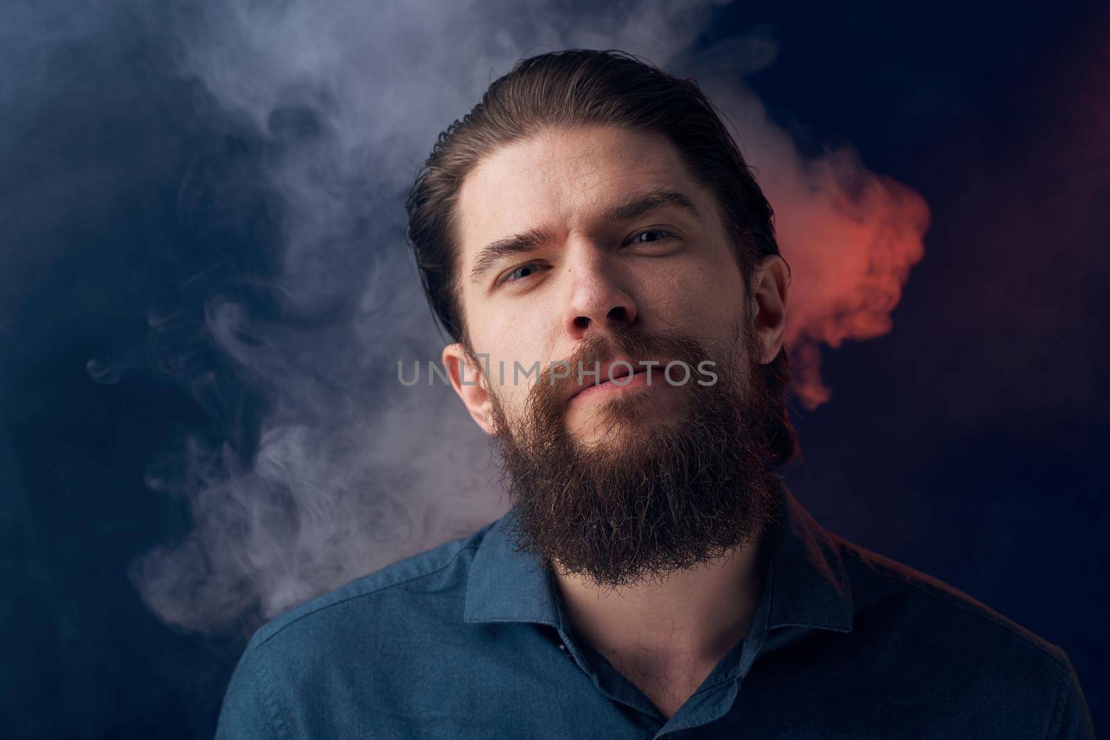 Emotional man black shirt attractive look close-up smoke in the background. High quality photo