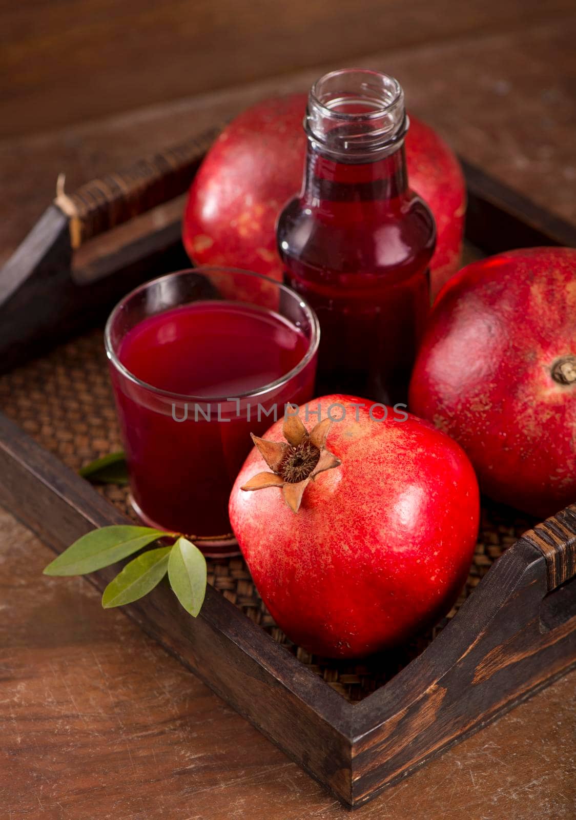 Glass of pomegranate juice and pomegranate fruit on wooden background