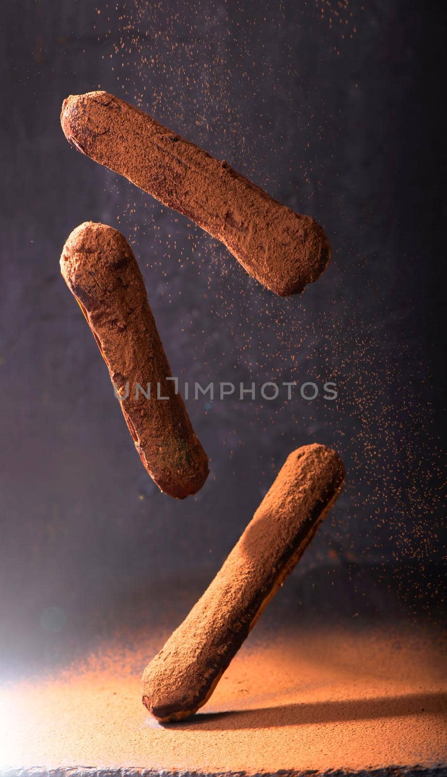 Traditional French dessert. Eclair with chocolate icing. Dark background